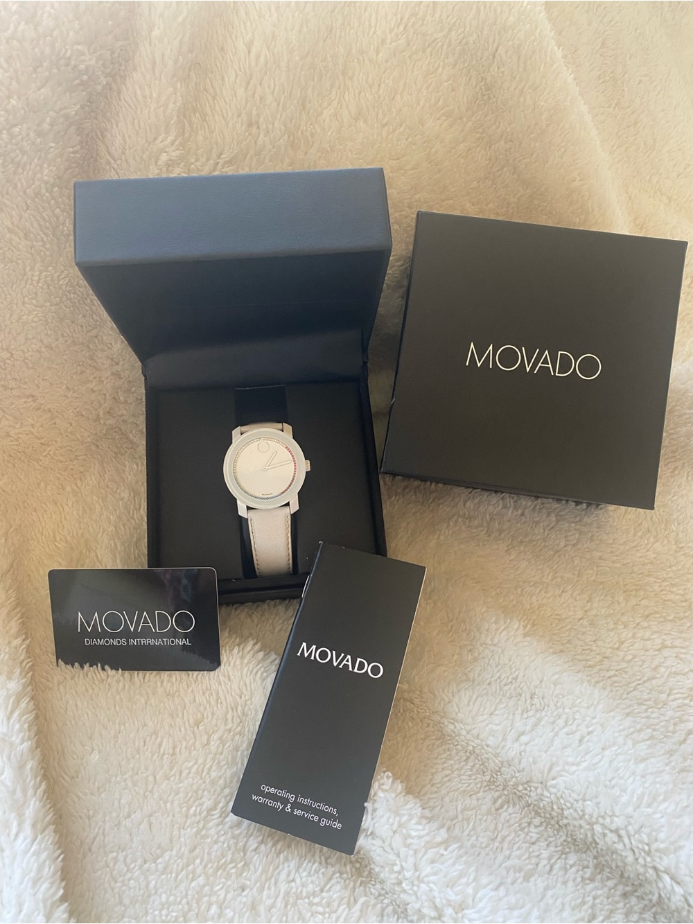 Movado watch with multiple colored crystals, white leather band and new battery